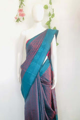 Peacock blue dual tone Banarasi silk saree with a contrasting designer border, comes with a running blouse piece.